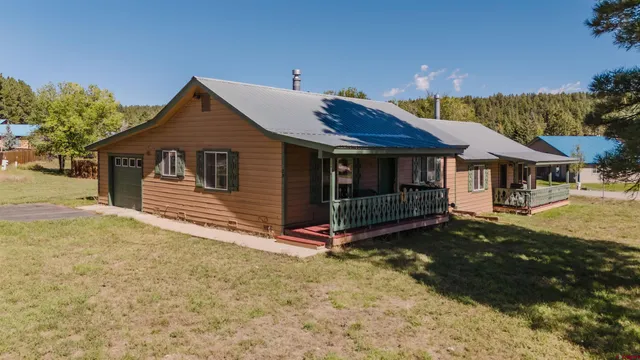 a view of a house with a yard and deck