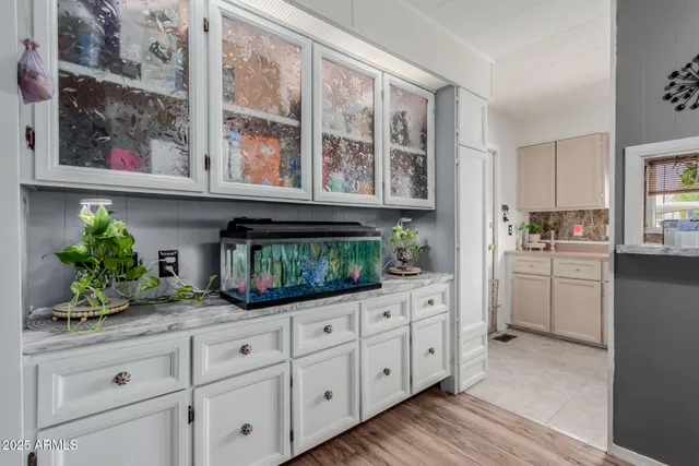 a kitchen with white cabinets and a wooden floor