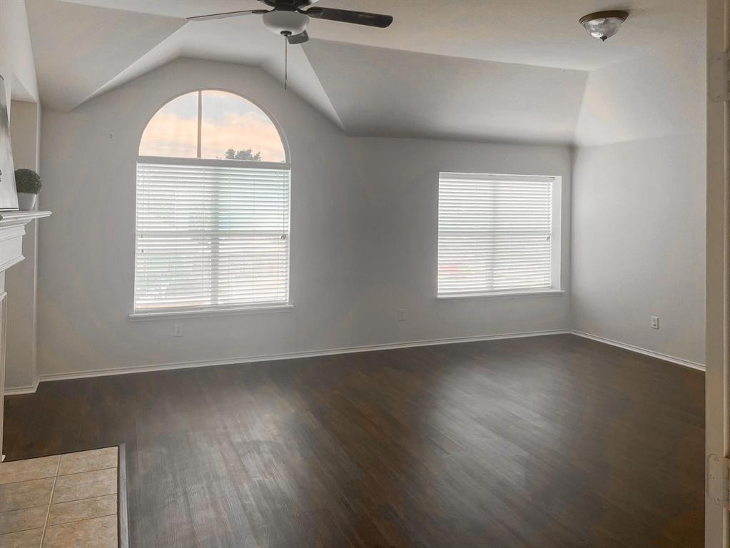 9305 Amber Downs Drive McKinney, TX 75072 - Photo 11 of 28 an empty room with wooden floor chandelier and windows