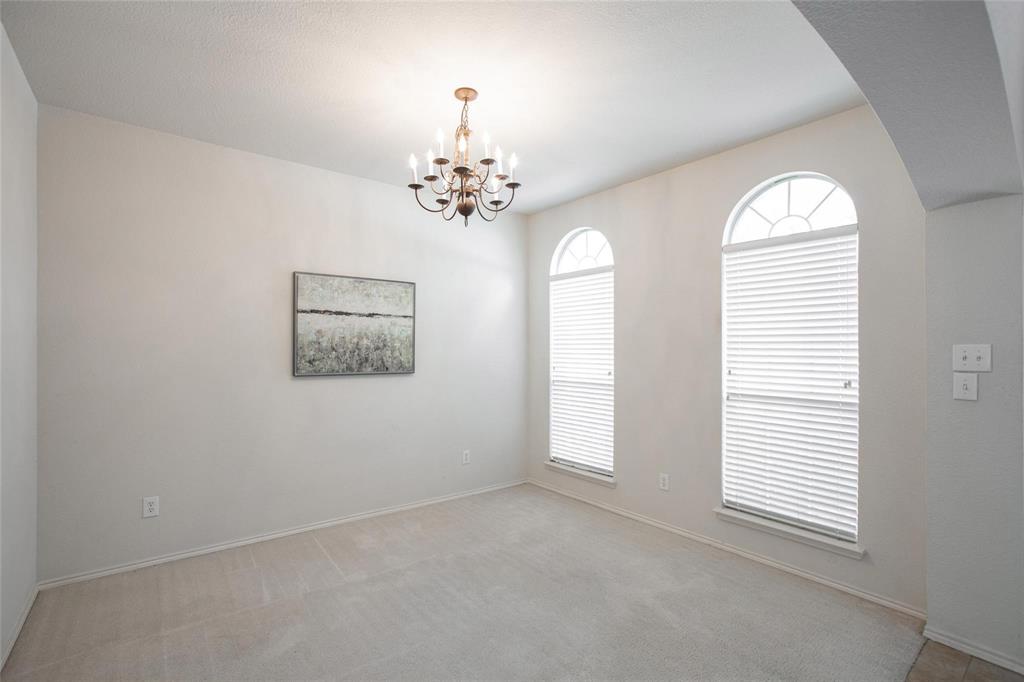 9305 Amber Downs Drive McKinney, TX 75072 - Photo 9 of 28 an empty room with windows and chandelier