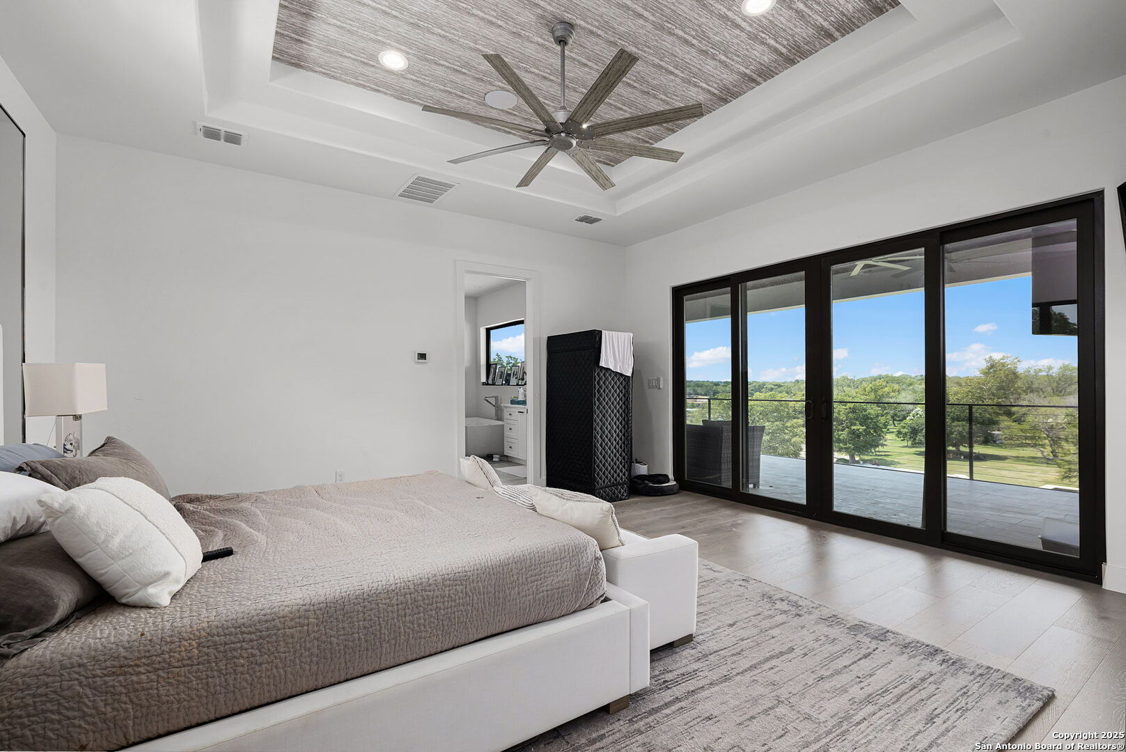 140 Rio Azul Seguin, TX 78155 - Photo 13 of 34 a bedroom with a large bed and a large window with balcony view