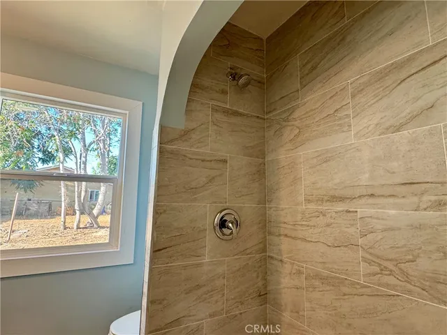 a bathroom with a window and a shower