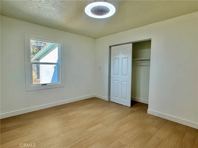 an empty room with window and closet