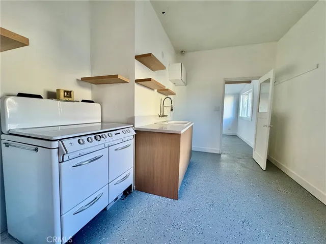a view of an empty room with a kitchen