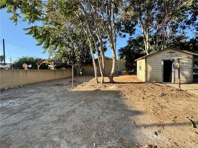 a backyard of a house with barbeque oven and glass table
