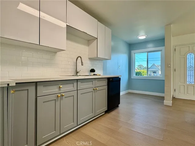 a kitchen with white cabinets and sink