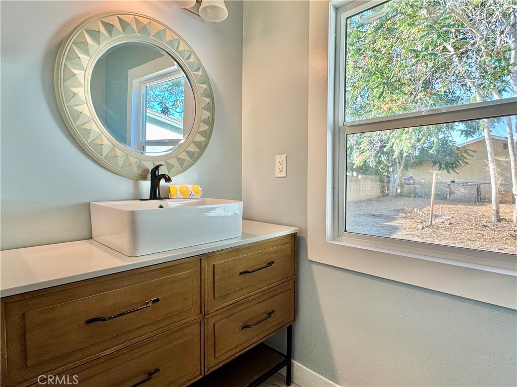 3944 East 9th Street Pomona, CA 91766 - Photo 9 of 22 a bathroom with a toilet sink mirror and window