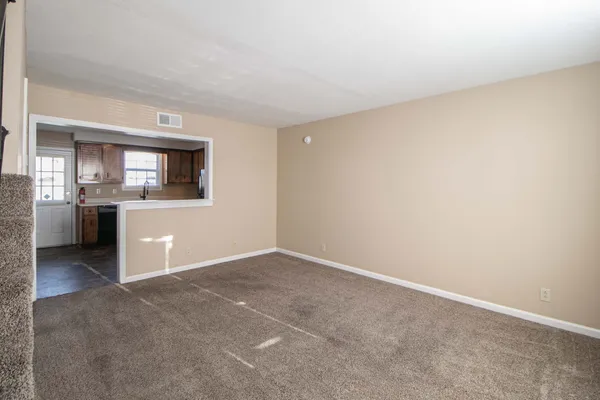 an empty room with a kitchen and a sink