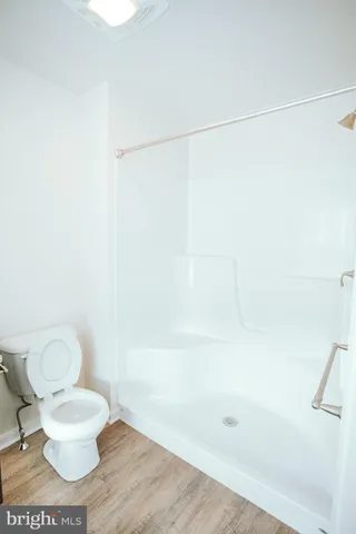 a white toilet sitting next to a shower