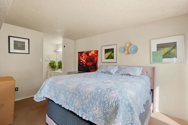 a bedroom with a bed and painting on the wall