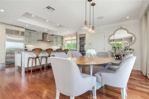 a view of a dining room with furniture a chandelier and wooden floor
