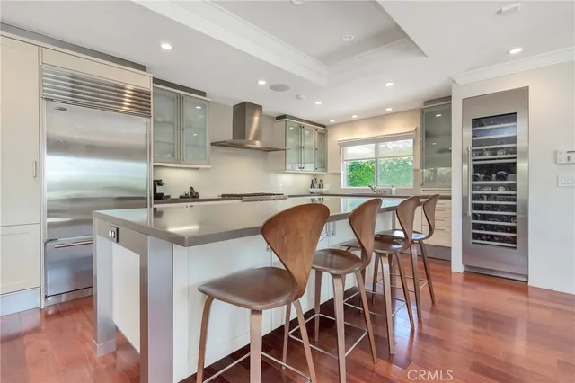 a kitchen with stainless steel appliances granite countertop a table chairs and a refrigerator