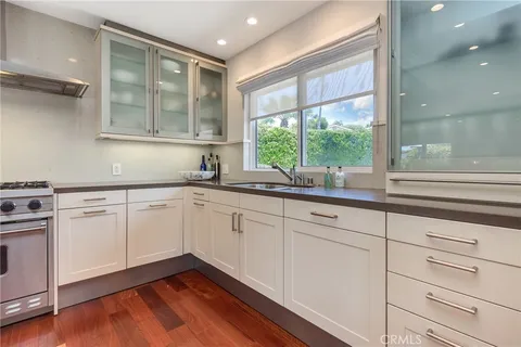 a kitchen with granite countertop white cabinets and a window