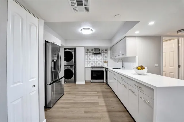 a kitchen with granite countertop white cabinets and stainless steel appliances