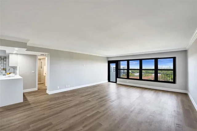 a view of an empty room with wooden floor