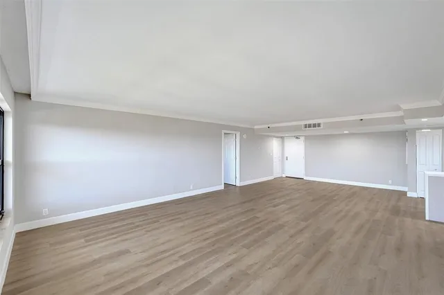 a view of an empty room and wooden floor