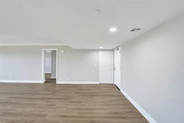 a view of an empty room with wooden floor