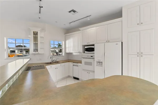 a kitchen with white cabinets and window