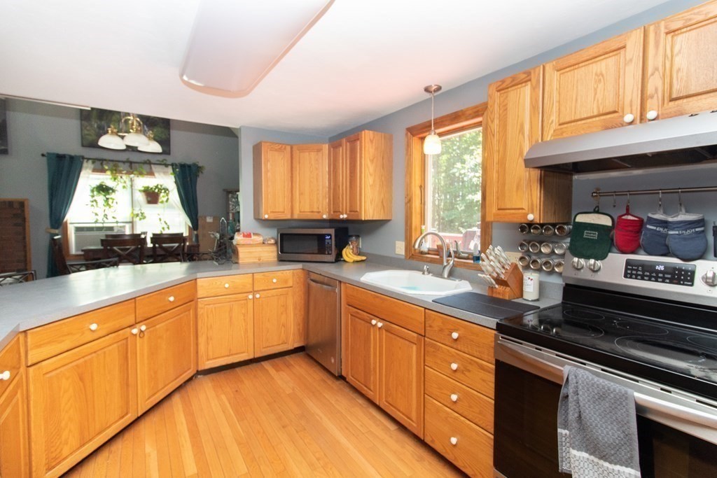 72 Bond Road Charlton, MA 01507 - Photo 9 of 36 a kitchen with stainless steel appliances granite countertop a sink a stove cabinets counter space and a large window