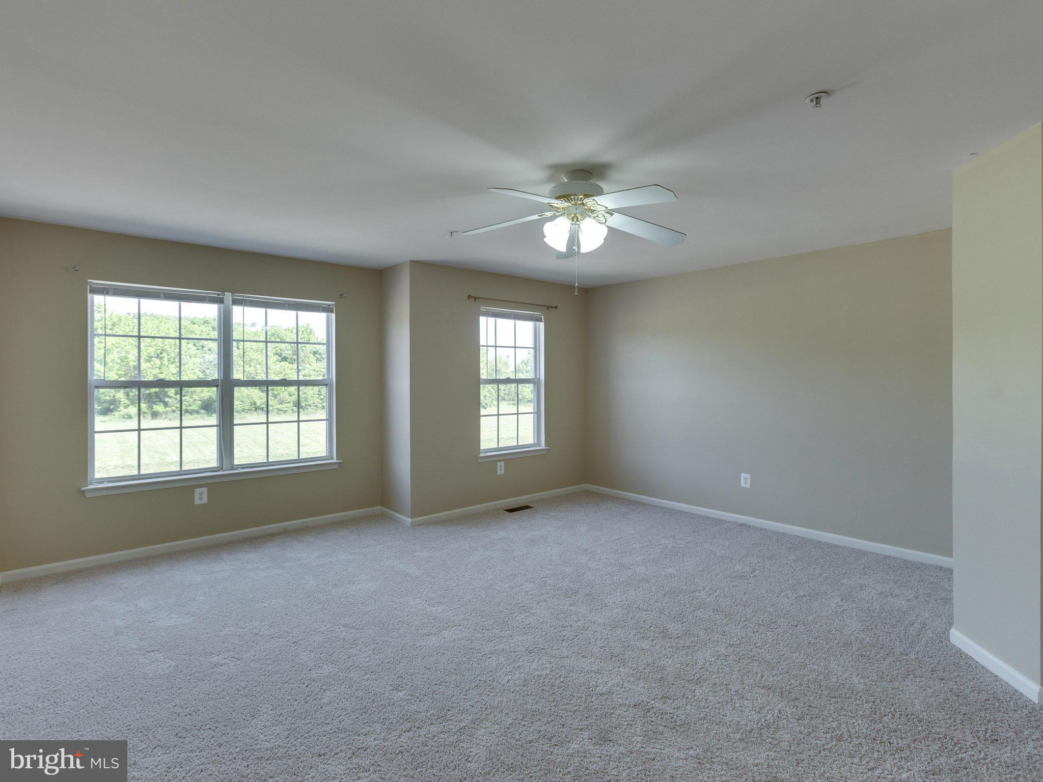 10613 Lockerbie Way Manassas, VA 20109 - Photo 22 of 27 an empty room with chandelier fan and windows