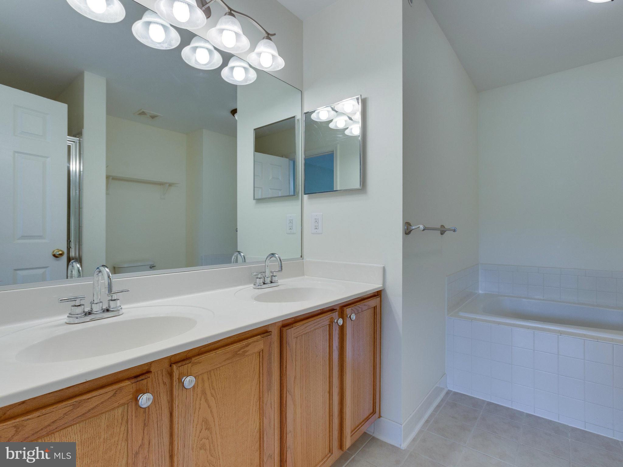 10613 Lockerbie Way Manassas, VA 20109 - Photo 24 of 27 a bathroom with a sink double vanity granite tub and a mirror