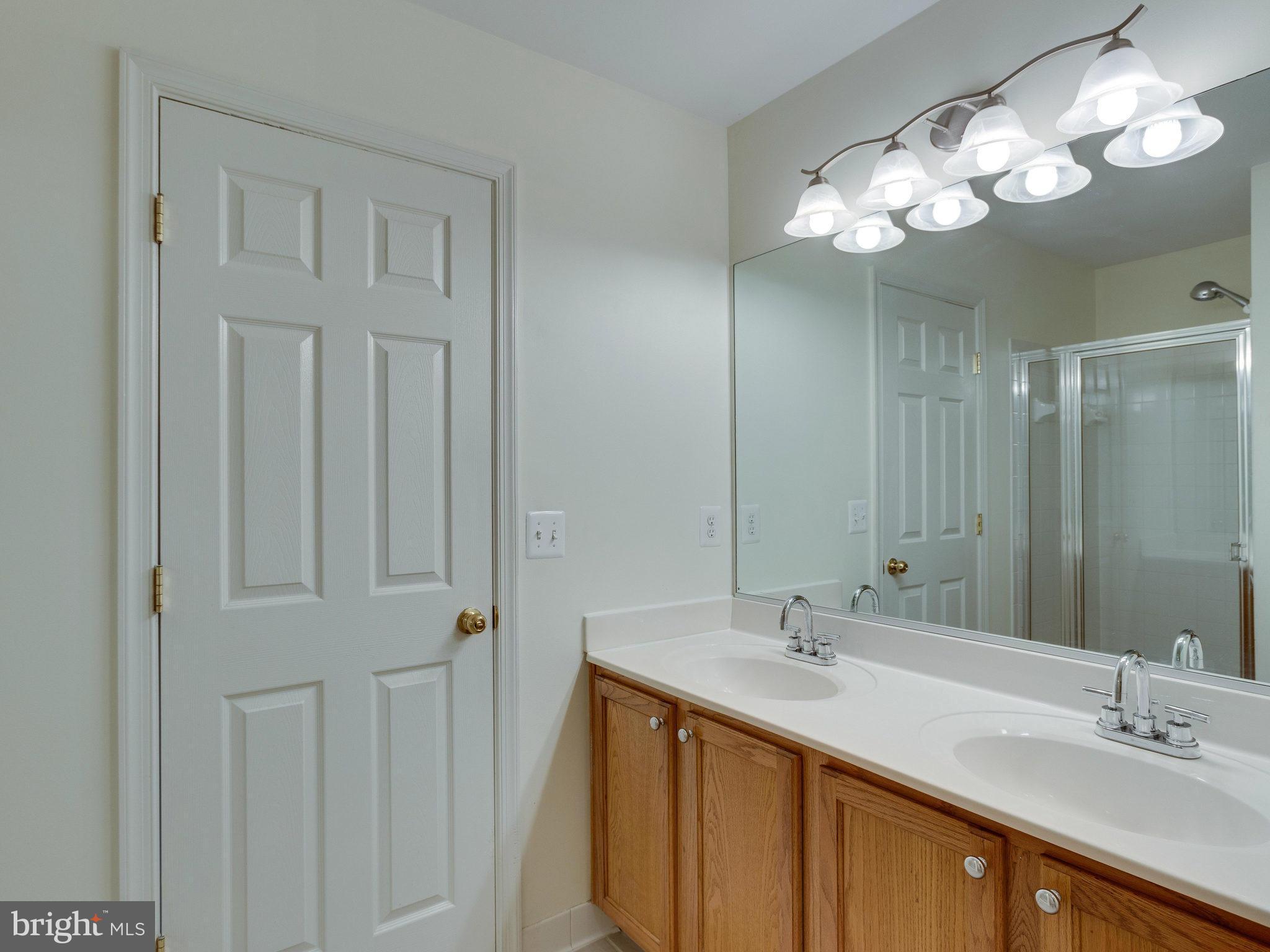 10613 Lockerbie Way Manassas, VA 20109 - Photo 25 of 27 a bathroom with double vanity sink a vanity and a mirror