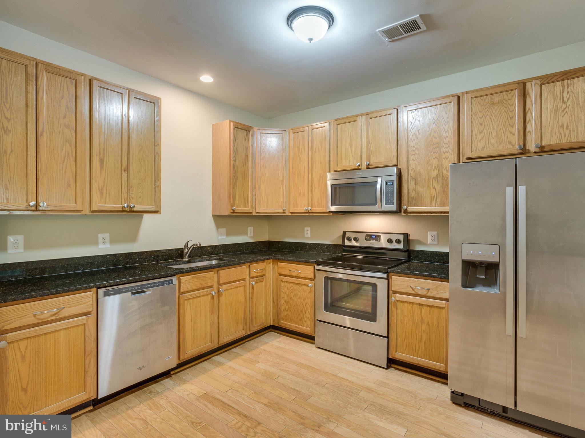 10613 Lockerbie Way Manassas, VA 20109 - Photo 10 of 27 a kitchen with stainless steel appliances granite countertop a stove a sink and a microwave