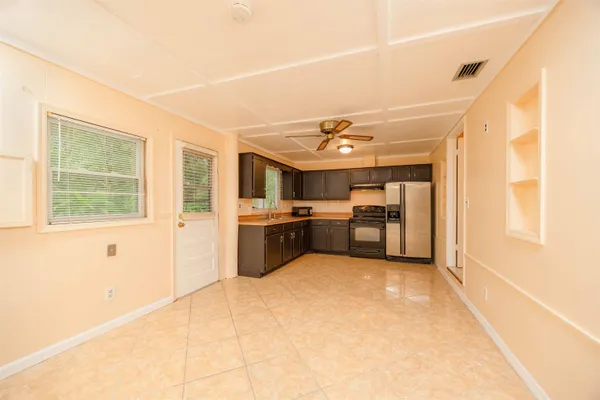 a large kitchen with a large counter top space appliances and cabinets