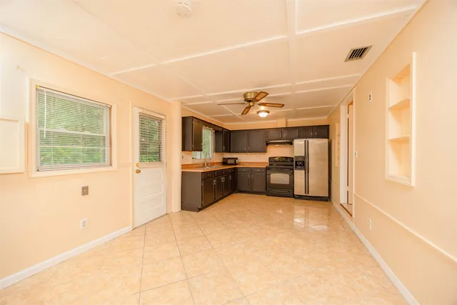 a large kitchen with a large counter top space appliances and cabinets