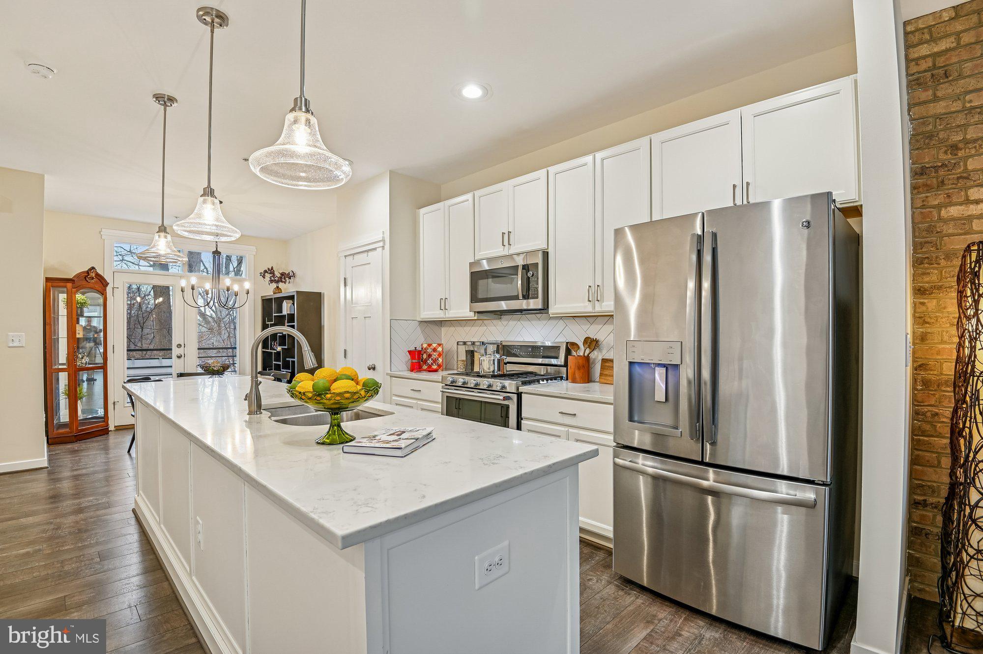 123 Lejeune Way Annapolis, MD 21401 - Photo 11 of 43 a kitchen with stainless steel appliances a refrigerator a sink dishwasher a oven a dining table and chairs with wooden floor