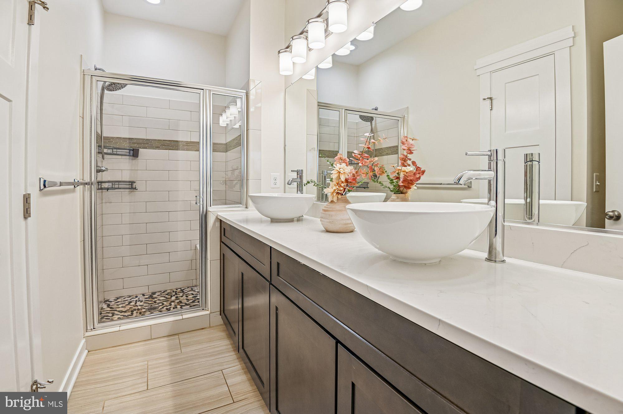 123 Lejeune Way Annapolis, MD 21401 - Photo 23 of 43 a spacious bathroom with a double vanity sink a mirror and a shower
