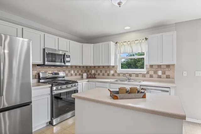 a kitchen with a sink a stove a refrigerator and cabinets