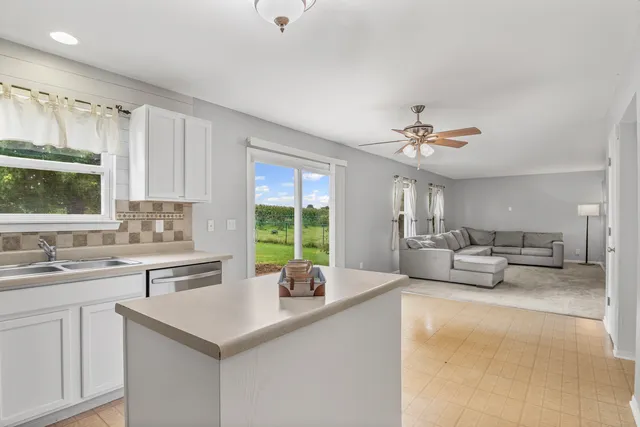 a kitchen with kitchen island a large counter top space appliances and a sink