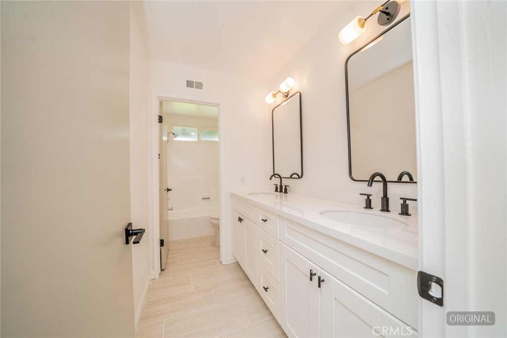 818 Terrace Road San Bernardino, CA 92410 - Photo 20 of 44 a bathroom with double vanity sink and mirror