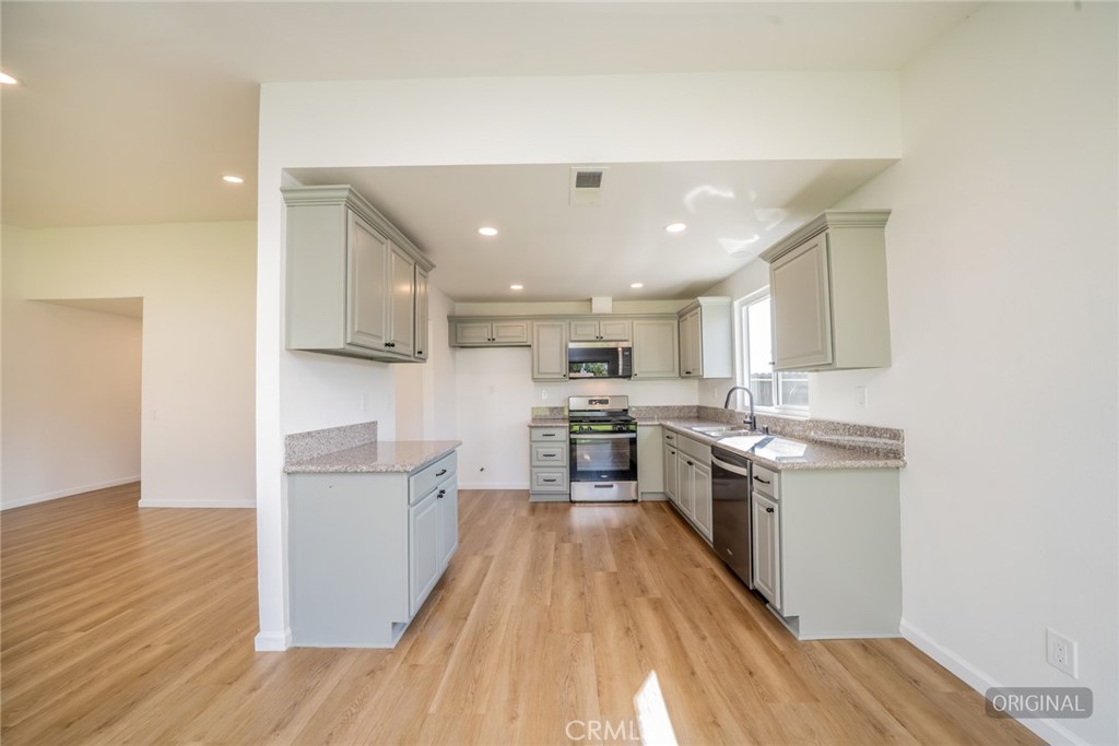 818 Terrace Road San Bernardino, CA 92410 - Photo 10 of 44 a kitchen with a sink wooden floor and stainless steel appliances