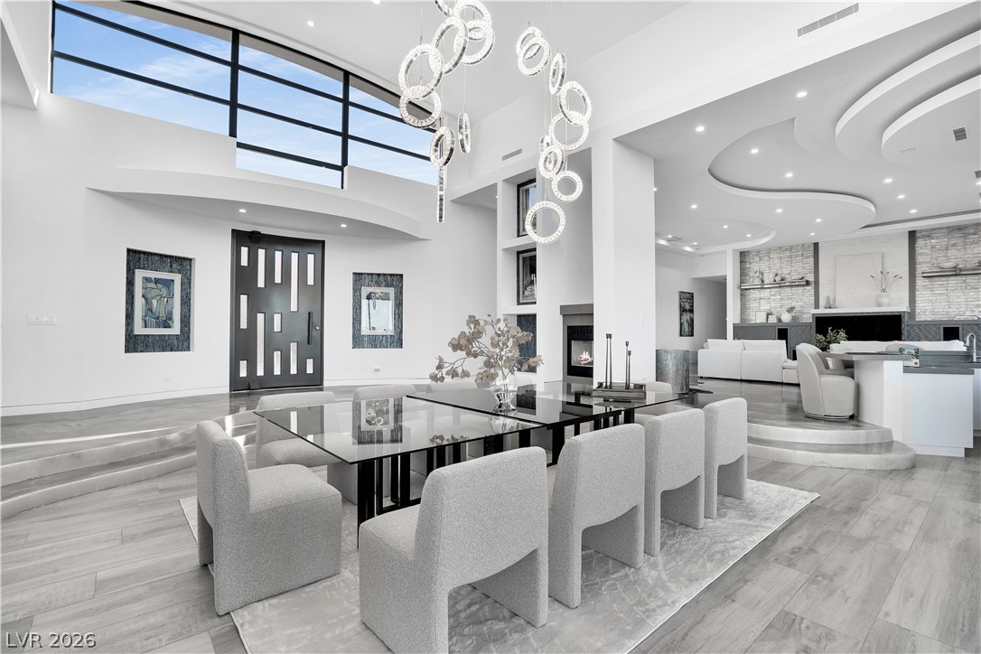 10 Ridge Blossom Road Las Vegas, NV 89135 - Photo 5 of 64 Natural light streams into this grand dining room, highlighting high ceilings and a cozy fireplace.