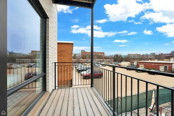 a view of a balcony with wooden floor next to a city