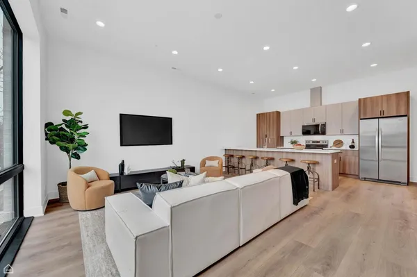 a living room with furniture kitchen and a flat screen tv