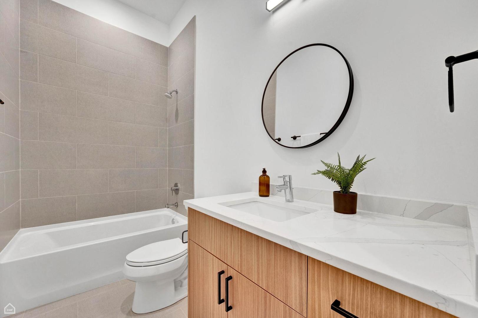 1607 West 13th Street, Unit 200 Chicago, IL 60608 - Photo 8 of 17 a bathroom with a granite countertop sink a toilet and a mirror