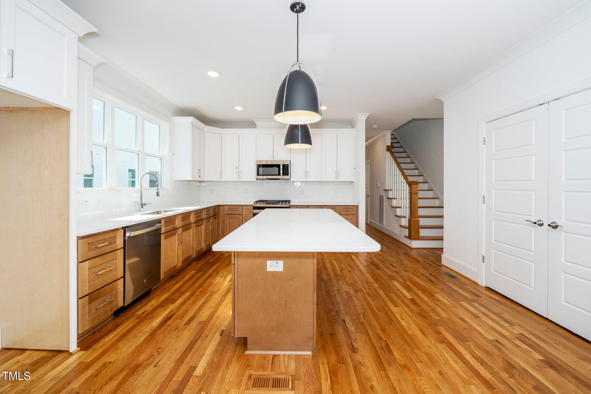 1211 Chaney Road Raleigh, NC 27606 - Photo 10 of 36 a kitchen with a sink appliances wooden floor and cabinets