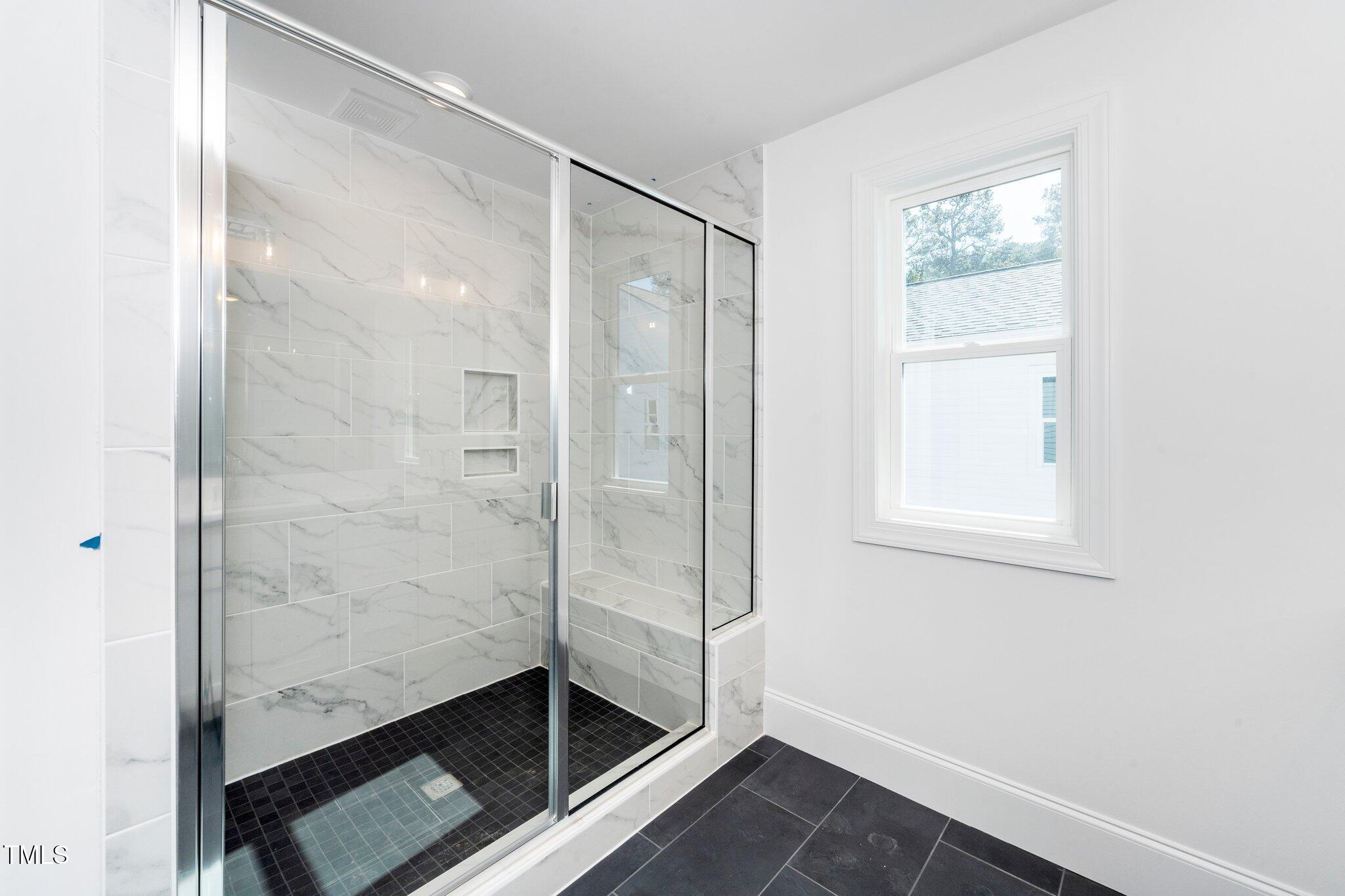 1211 Chaney Road Raleigh, NC 27606 - Photo 30 of 36 a bathroom with a glass shower door