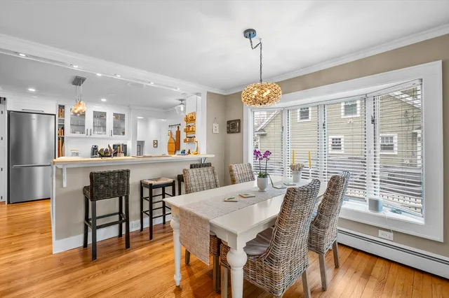 a view of a dining room and livingroom with furniture wooden floor a chandelier