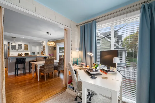 a view of a workspace with furniture and a large window