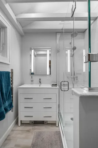 a bathroom with a double vanity sink mirror and shower