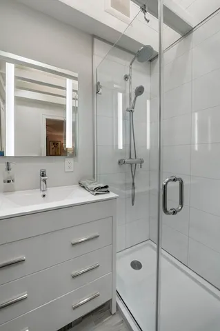 a bathroom with a double vanity sink mirror and shower