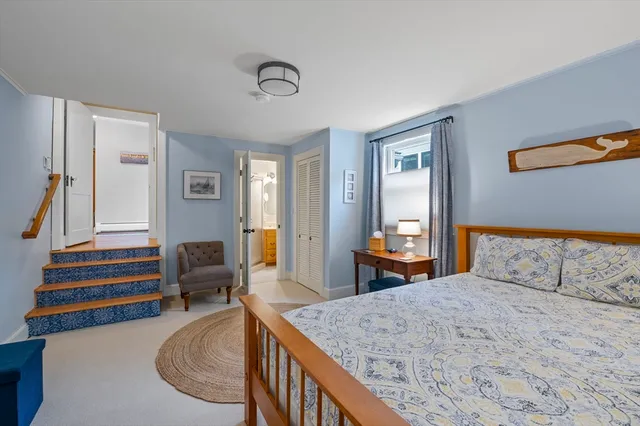 a bedroom with a bed and dresser with mirror