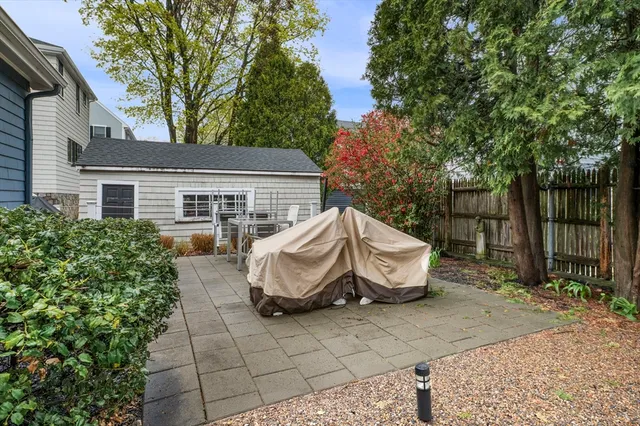 a view of a patio with chair and table and chairs and wooden fence