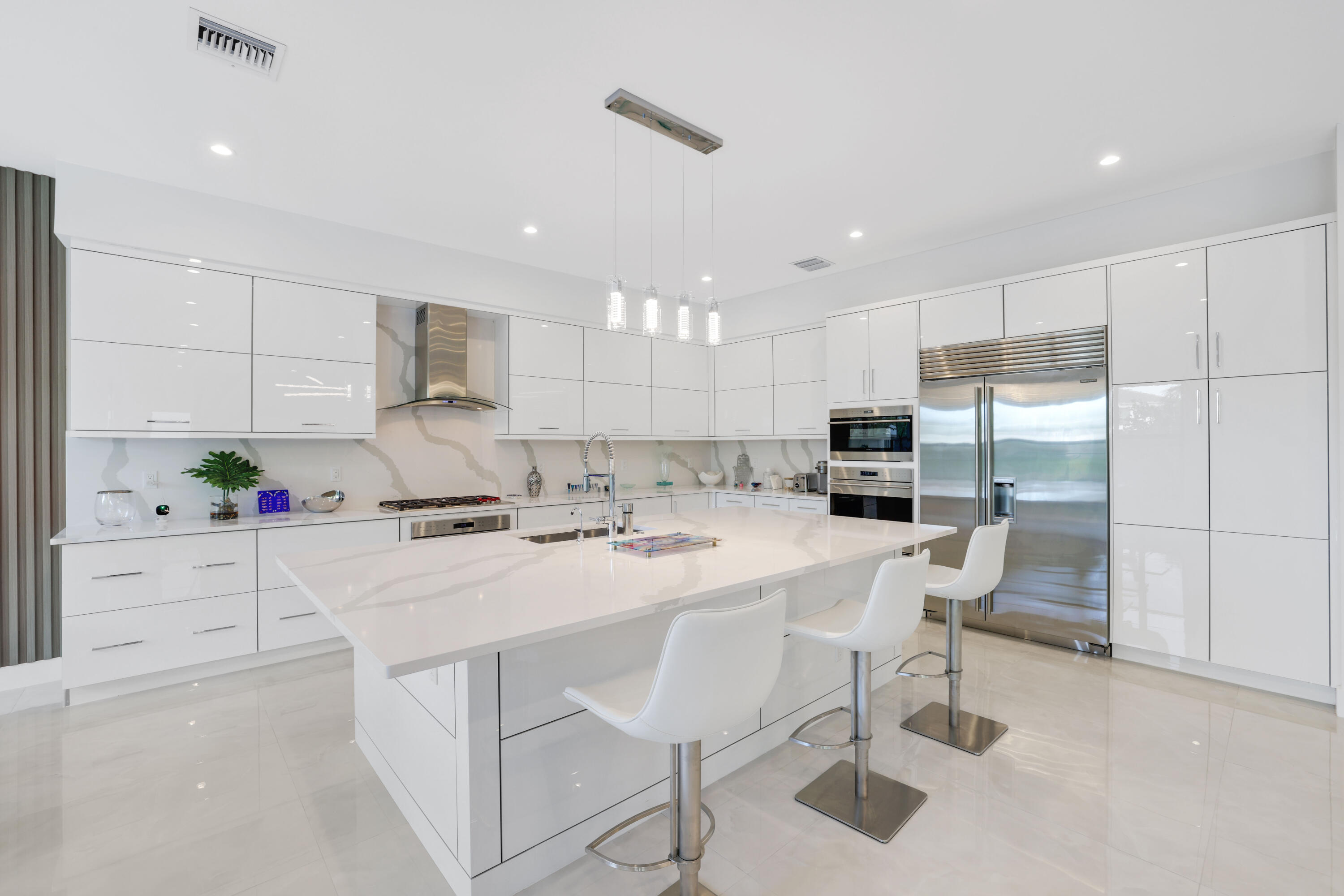 17052 Rainbow Fls Trail Boca Raton, FL 33496 - Photo 24 of 96 a kitchen with kitchen island a stove a table and chairs in it