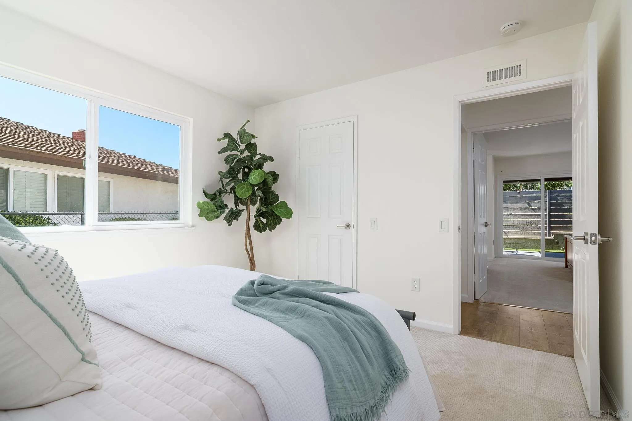 16556 Gabarda Road San Diego, CA 92128 - Photo 25 of 42 a bedroom with a large bed and a potted plant