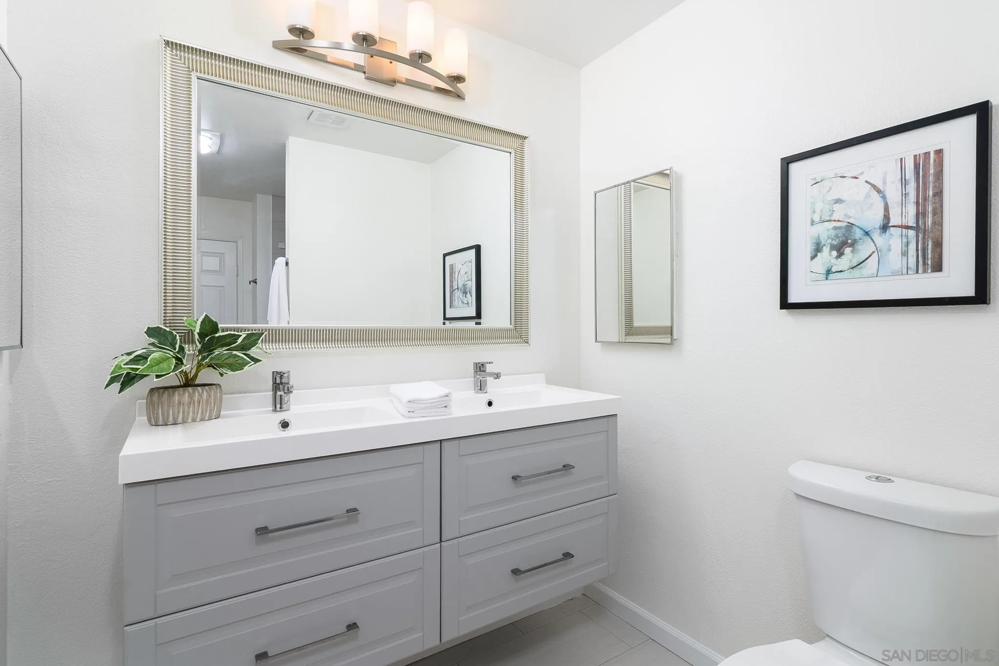 16556 Gabarda Road San Diego, CA 92128 - Photo 27 of 42 a bathroom with a toilet sink and mirror